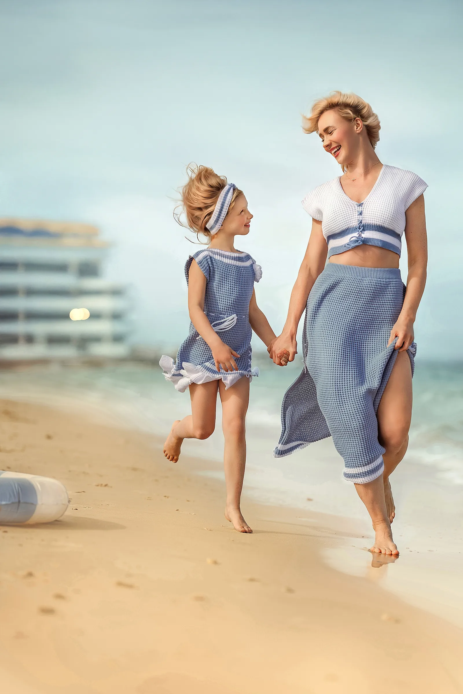 Familia vistiendo conjuntos de punto calado azul de Michiada en la playa.